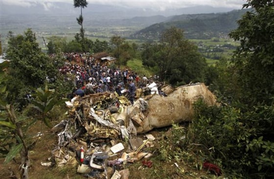 Nepalese rescue workers and civilians gather around the wreckage of a Beechcraft 1900D operated by Buddha Air after it crashed in the mountains outside Bisankunarayan village, just south of Katmandu, Nepal, early Sunday.